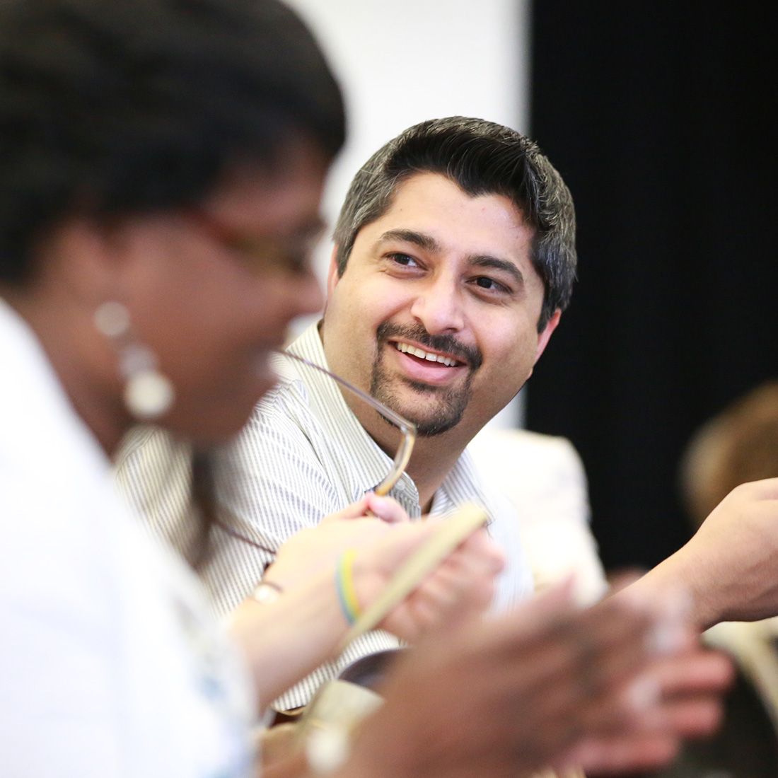 A middle aged man looking at a colleague and smiling